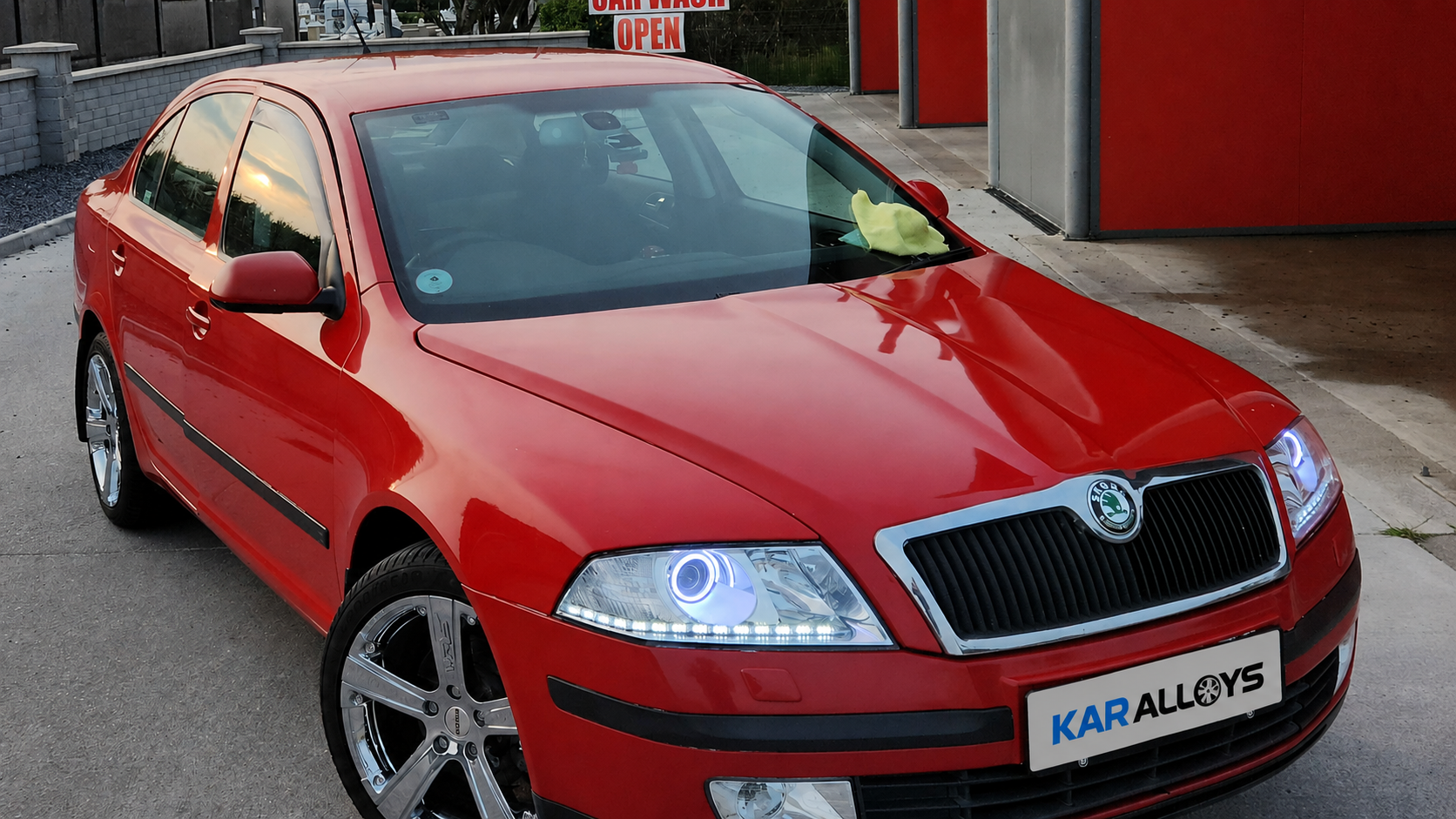 Red Škoda Octavia with chrome alloy wheels and illuminated custom headlights